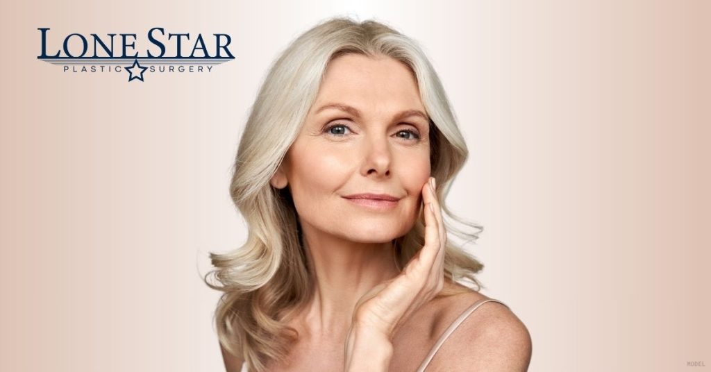 Mature woman gently touching her face while posing for the camera (model)